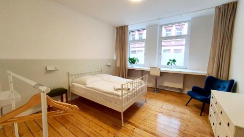 a bedroom with a bed and a desk and two windows at Zimmer im Erdgeschoss in Mannheim