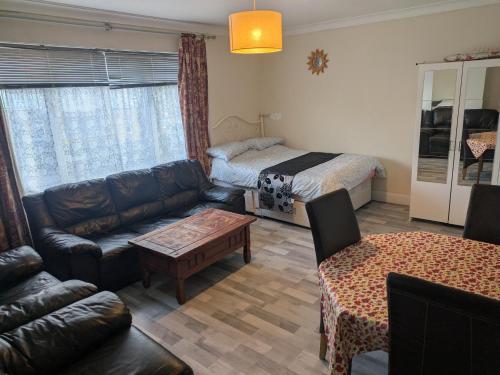 a living room with a couch and a bed at DACH Apartments - Cozy 3 bed Apartment in Hendon in Colindale