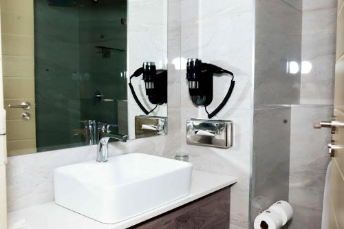 a bathroom with a sink and two phones on the wall at Q's Evander Hotel & Apartments in Evander