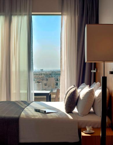 a bedroom with a bed with a window with a pen on it at Zeus Thessaloniki Lazart in Thessaloniki