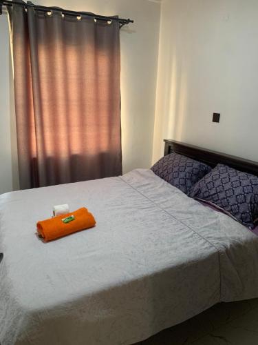 a bed with an orange towel on top of it at Kisumu gateway 2br in Kisumu