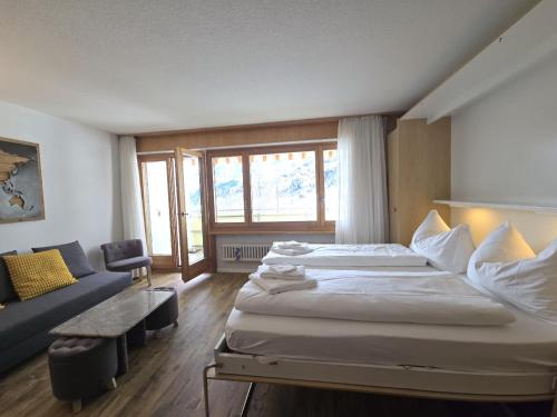 a hotel room with two beds and a couch at Panorama 20, Grosses Studio, Nahe Ski-Pisten, Parkplatz in Leukerbad