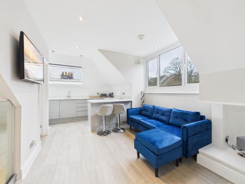 a living room with a blue couch and a table at The loft apartment in Bromley
