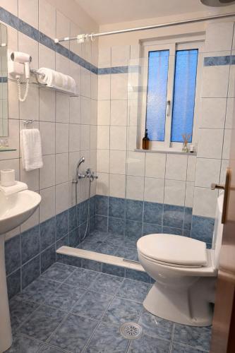 a bathroom with a shower and a toilet and a sink at Art Suites Mesologgi in Missolonghi