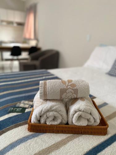 a pile of towels sitting on top of a bed at Studio Aconchegante e Moderno in Castanhal