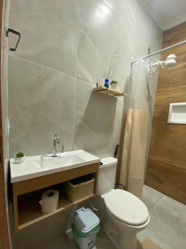 a bathroom with a toilet and a sink and a shower at Studio Aconchegante e Moderno in Castanhal