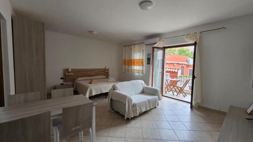 a living room with a bed and a table and a chair at Monolocale in centro con parcheggio privato! in Palau