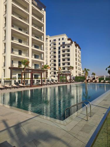 a large swimming pool in front of some buildings at Yas Park View Studio Abu Dhabi Yas Island in Abu Dhabi
