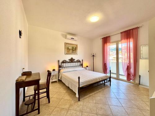a bedroom with a bed and a desk and a window at Skyline Terrace in Loceri