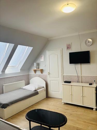 a bedroom with a bed and a tv and a table at Anna Vendégház Szilvásvárad in Szilvásvárad