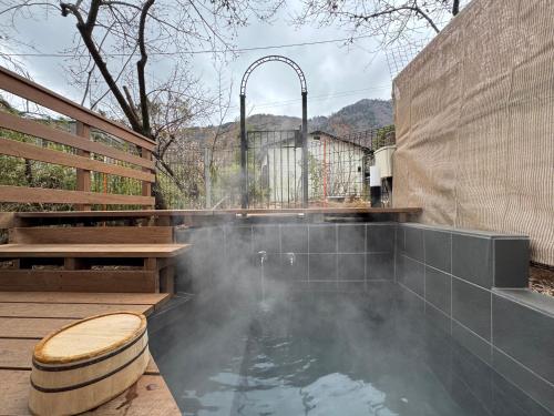 a hot tub in a backyard with a fountain at Yamaguchi House Annex, Private House with Onsen in Hakone