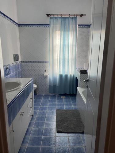 a blue and white bathroom with a sink and a shower at Αρχοντικό Λίθος in Kastoria