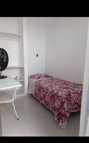 a small bedroom with a bed with a red blanket at Casa na várzea Quarto 1 in Recife