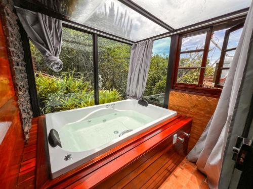 a bath tub in a room with a window at Pousada e Restaurante Vista Turquesa in Arraial do Cabo