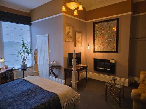 a bedroom with a bed and a fireplace in it at Ashburton House - B&B in Scarborough
