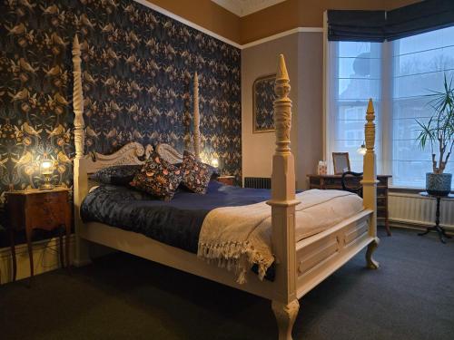 a bedroom with a canopy bed and a window at Ashburton House - B&B in Scarborough