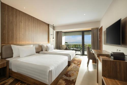 a hotel room with two beds and a television at Royal Ambarrukmo Yogyakarta in Yogyakarta
