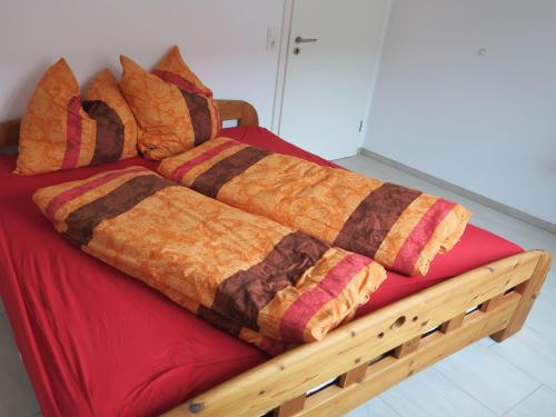 a bed covered in blankets and pillows at Ferienhof Windegg in Stockach
