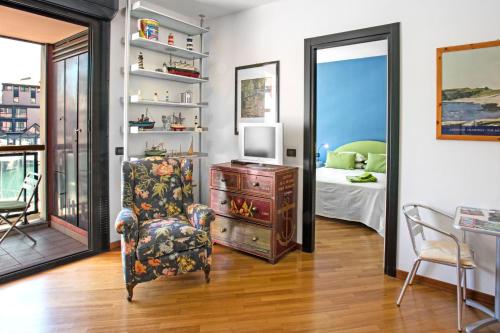 un soggiorno con sedia e TV e una camera da letto di Sull'Acqua del Porto Antico a Genova