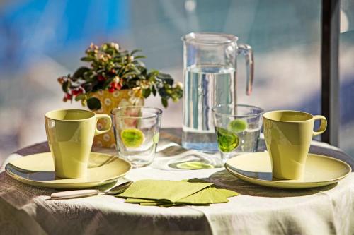 un tavolo con due tazze verdi e due piatti sopra di Sull'Acqua del Porto Antico a Genova