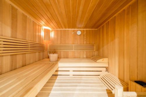 a sauna with two benches and a clock in it at Wippas Landhaus in Ischgl