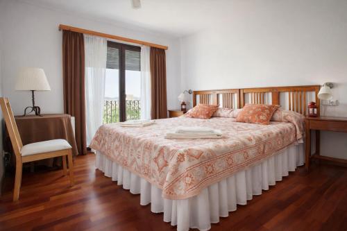 a bedroom with a large bed and a window at Apartament amb vistes al castell - Cal Martí in Montsonis