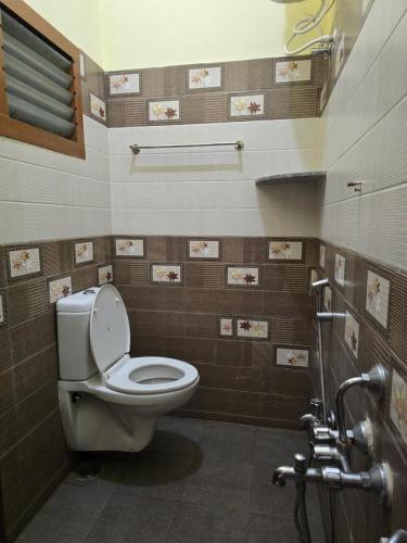 a bathroom with a toilet in a room at Yercaud Misty Haven in Yercaud