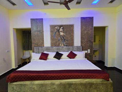 a bedroom with a large white bed with red pillows at Yercaud Misty Haven in Yercaud