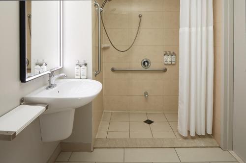 a bathroom with a sink and a shower at Holiday Inn & Suites Montreal Airport by IHG in Dorval