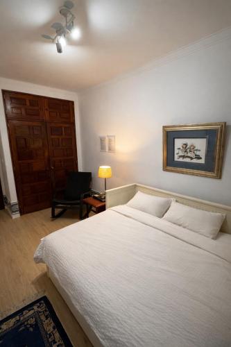 a bedroom with a large white bed and a chair at Double Room near Lisbon & Sintra in Queluz