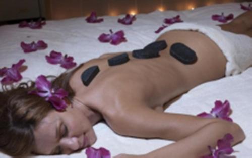 a woman laying on a bed with purple flowers at Albergo Milano in Boario Terme