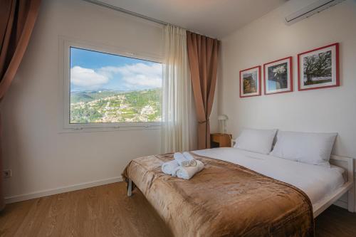 a bedroom with a bed with a large window at Madeira High View in Funchal