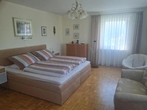 a bedroom with a bed and a couch and a chair at Ferienwohnung Schabmüller in Kelheim
