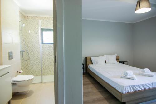 a bedroom with a bed and a toilet and a shower at QUANICE - Relaxing Guest House in Faro in Faro