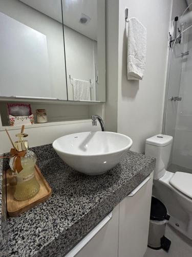 a bathroom with a white bowl sink on a counter at Loft Studio bem localizado e novinho in Passo Fundo