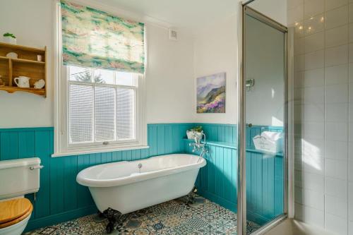 a blue bathroom with a tub and a window at 3 Bed in Gosforth oc-s34885 in Gosforth