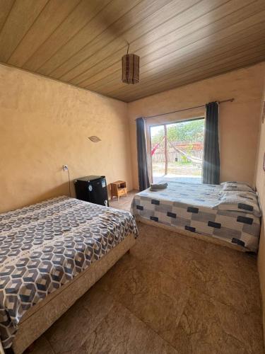 a bedroom with two beds and a window at Vila Macapaz Kitesurf in Luis Correia