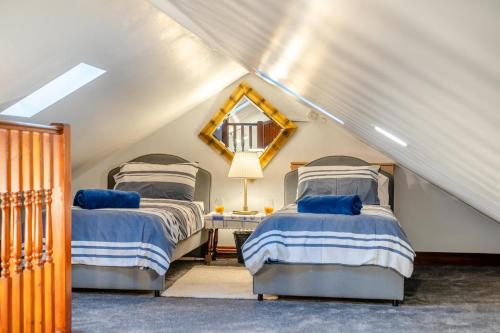 a attic bedroom with two beds and a mirror at 2 Bed in Escomb oc-o34978 in Acomb