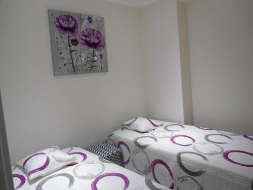 two beds in a room with a painting on the wall at Bay View Apartment Albufeira in Albufeira