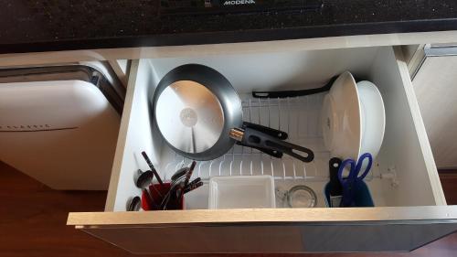 un cajón lleno de utensilios de cocina en un microondas en Papilukas Room Kalibata City - Studio Silver, en Yakarta