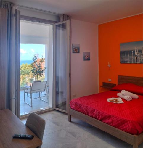 a bedroom with a red bed and a balcony at AmarMare Bed&Breakfast in Trappeto
