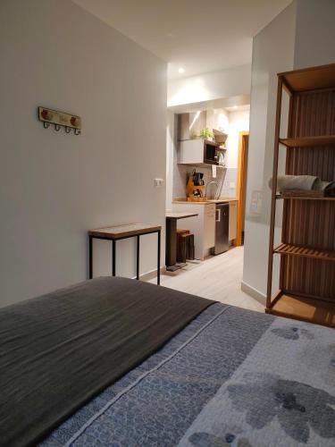 a bedroom with a bed and a desk and a kitchen at Gazteategi in Zarautz