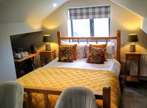 a bedroom with a bed with a yellow bedspread at Englefield Guesthouse in Goathland