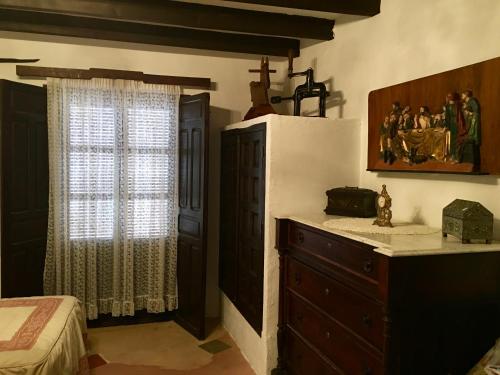 アルカラスにあるCasa Rural Bracamonteのベッドルーム1室(ベッド1台、ドレッサー、窓付)