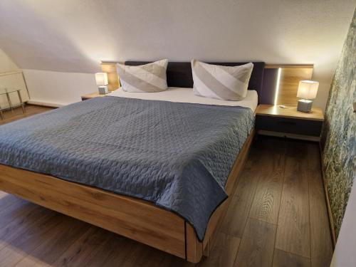 a bedroom with a large bed with two tables and two lamps at Lange Str. 15 - Ferienwohnung in Prerow