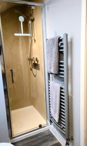 a shower stall in a bathroom with towels at Englefield Guesthouse in Goathland
