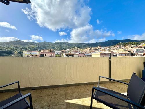 a balcony with chairs and a view of a city at Skyline Balcony in Loceri