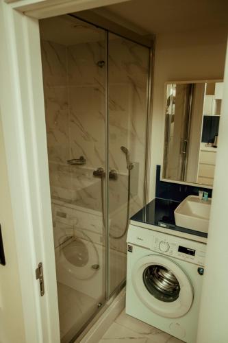 a bathroom with a shower and a washing machine at Orbi HighView Panoram Hotel in Batumi