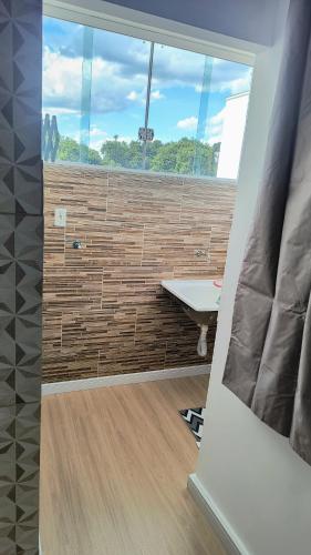 a room with a table and a large window at Flat Equipado no Centro - Conforto in Governador Valadares
