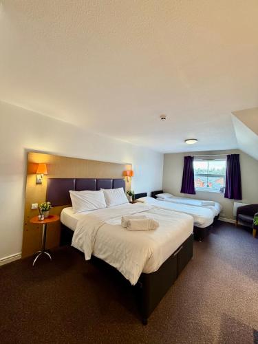 a hotel room with two beds and a window at Premier Nights, Wigan, Standish M6 J27 in Standish